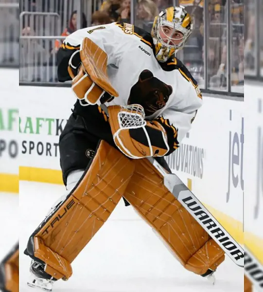 Linus Ullmark sliding his hockey in a match wearing Boston Bruins jersey