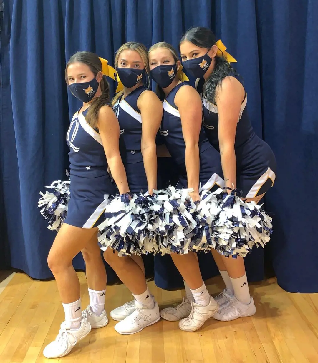 Cheerleaing Team Of The University Dressed In Blue With Yellow Bow Rubber Bands